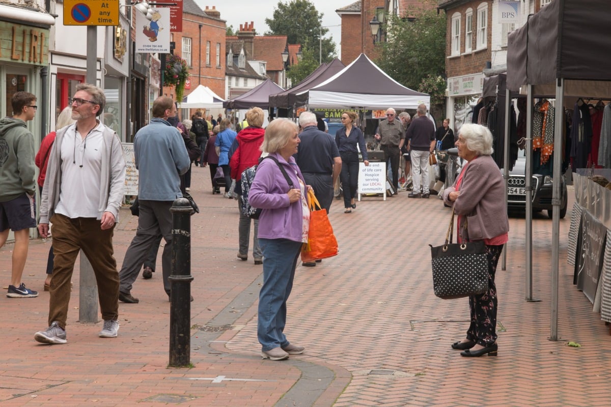 View of shoppers at a street market. Two older women having a conversation