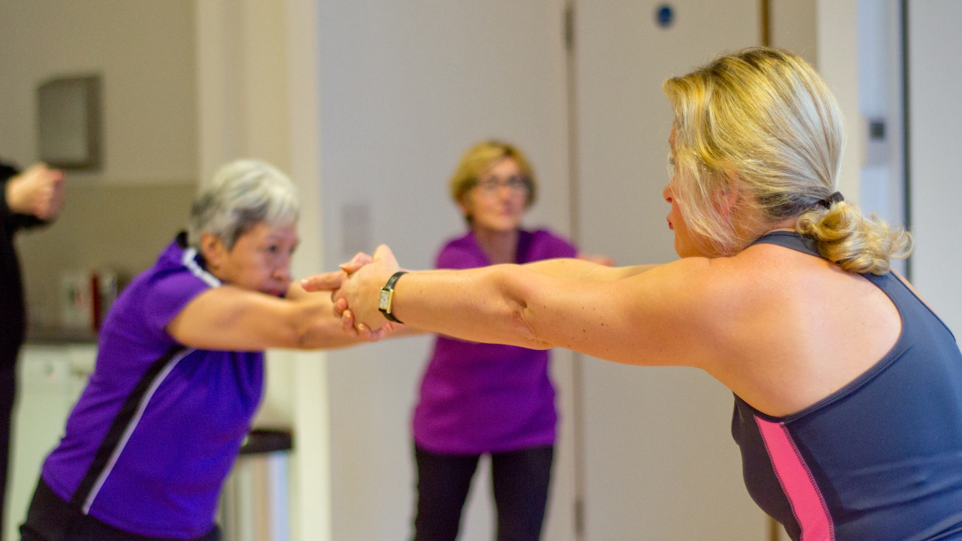 Two woman stretching arms