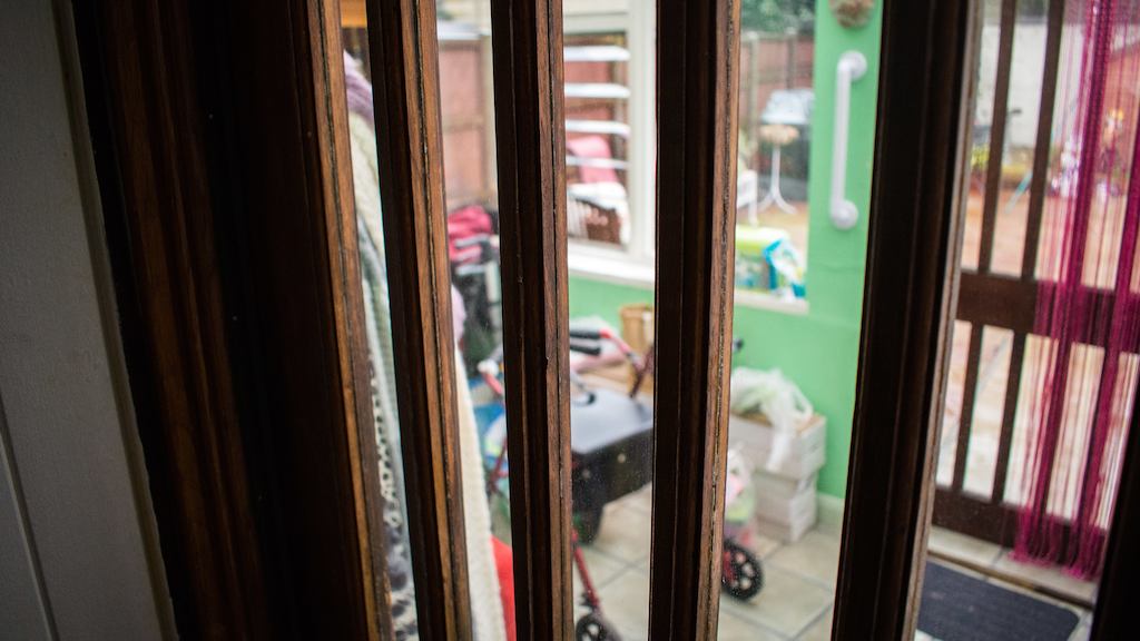 A home entrance with a grab rail and a rolling walker.