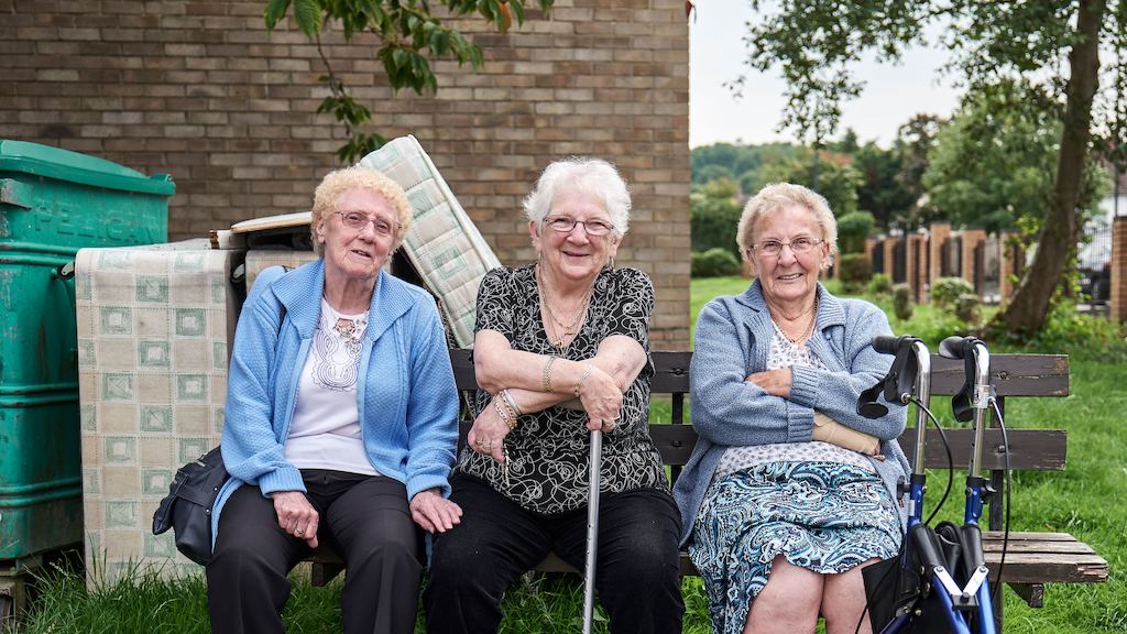Three ladies in later life sitting on a bench