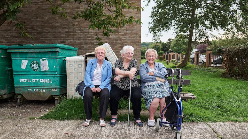 Three older women sitting on bench