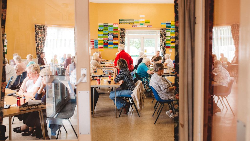 Group of older people sitting by tables