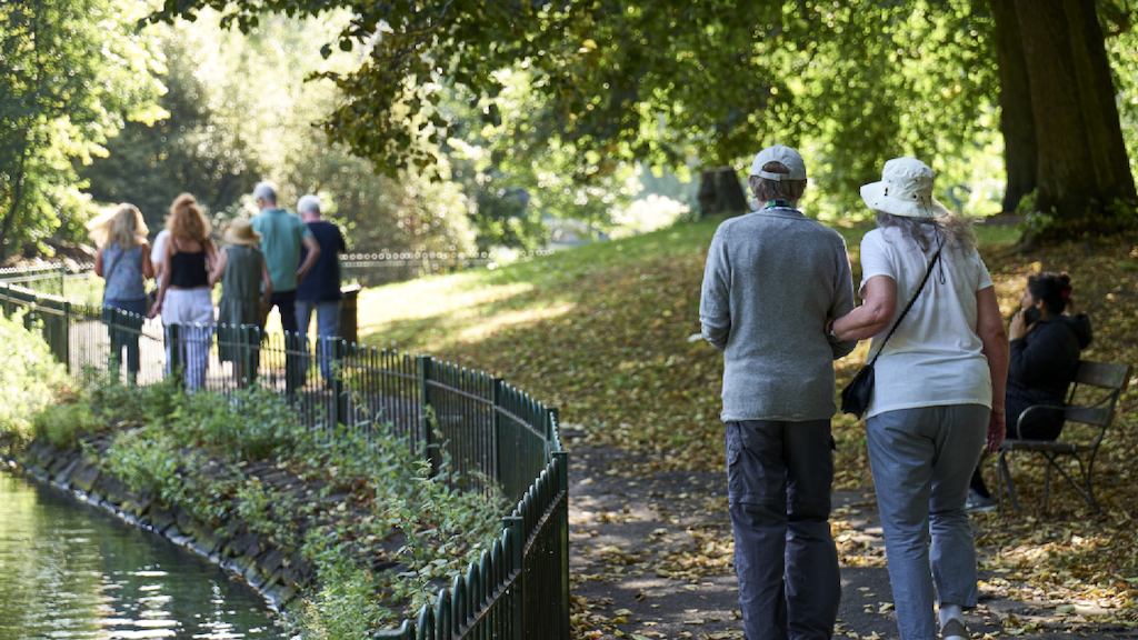 group of older people walking outside in a park