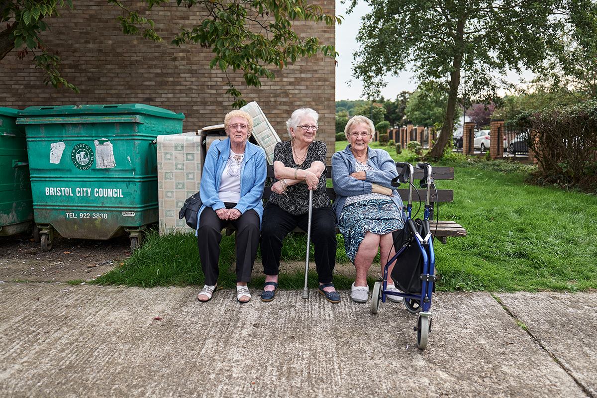 Group of older ladies sitting on a bench smiling